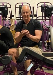 A fit senior man in a weightlifting gym. 