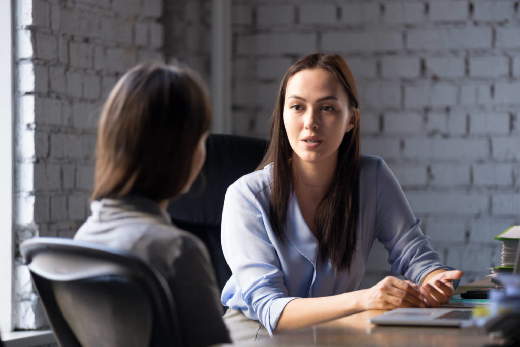 A photo of a difficult conversation between two young women in an office.