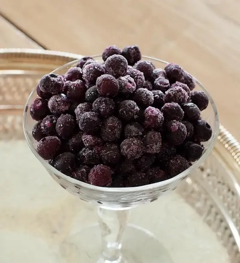 A photo of blueberry recipes featuring Vital Choice frozen blueberries in a crystal glass.