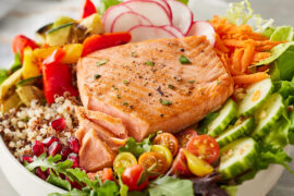 Omega-3 salmon in a bowl with quinoa and other vegetables.