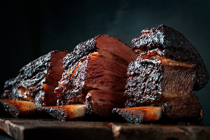 A closeup shot of. barbecue-meat-on a wooden plank.