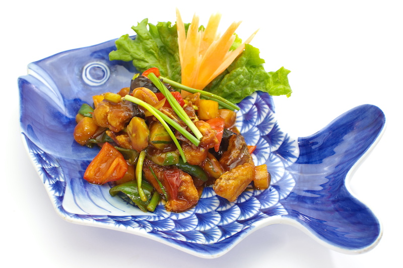Sweet and sour fish on a blue fish dish.