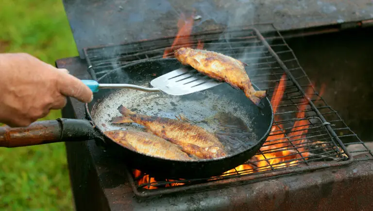 fish fry with fish frying in oil over a fire