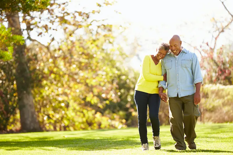 Benefits of walking, happy couple walking in park.