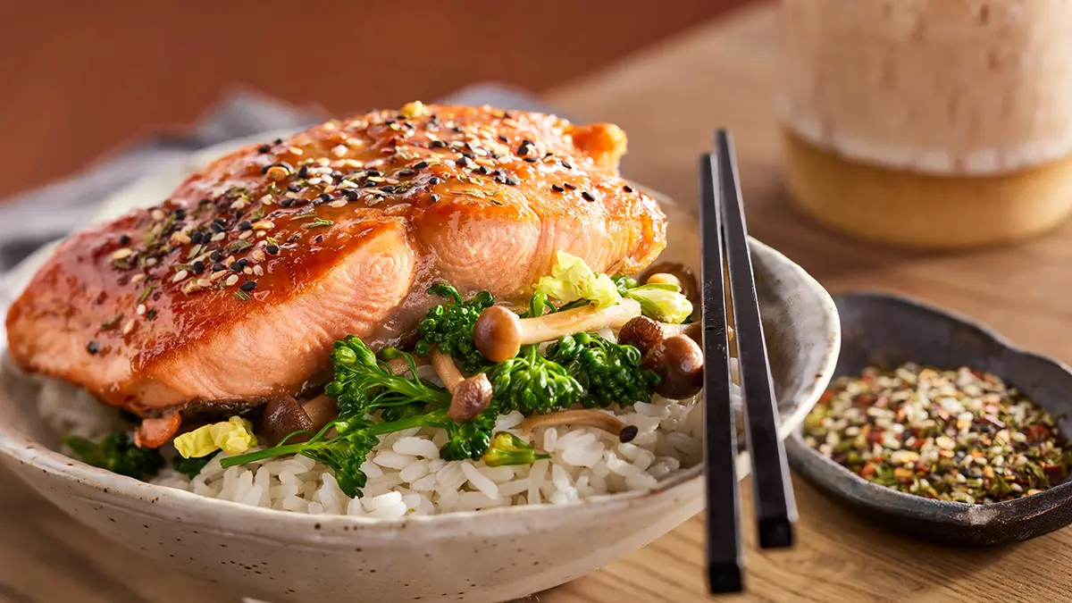 Bowl of rice with salmon and vegetables.