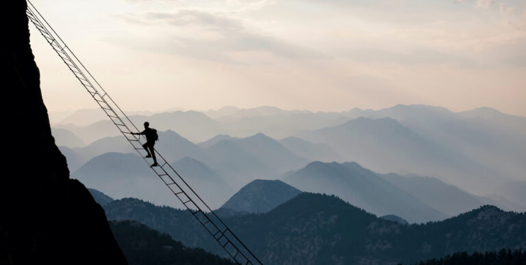 High Altitude Living man on ladder in mountains