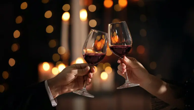romantic dinner ideas with a couple toasting wine glasses.