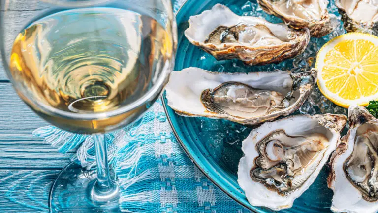 Wine with fish and oysters on a plate.