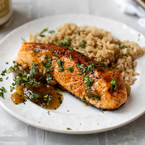 Atlantic salmon with pineapple relish on a plate with rice.