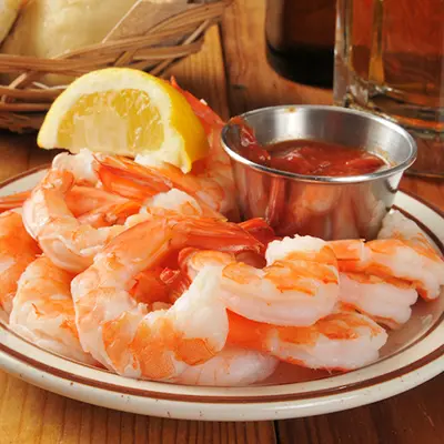 Seafood recipes with a plate of shrimp and cocktail sauce.