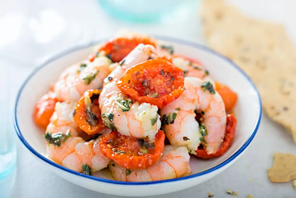seafood tapas marinated king prawns with cherry tomatoes and basil olive oil