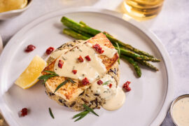 Broiled halibut on a plate with lime aioli and asparagus.