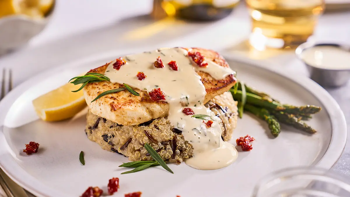 Broiled halibut on a plate with lime aioli and asparagus.