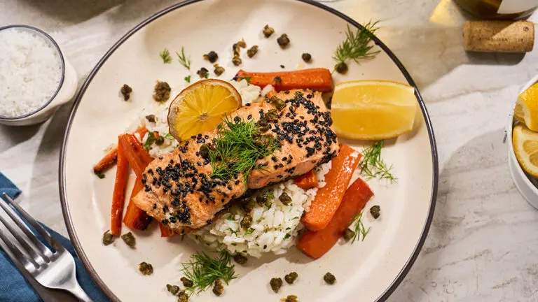 King salmon recipe with carrots and lemon on a plate.