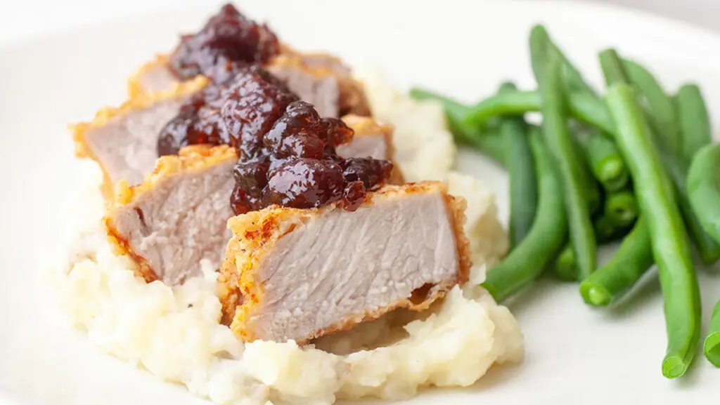 Pork chop recipe with green beans and mashed potatoes.
