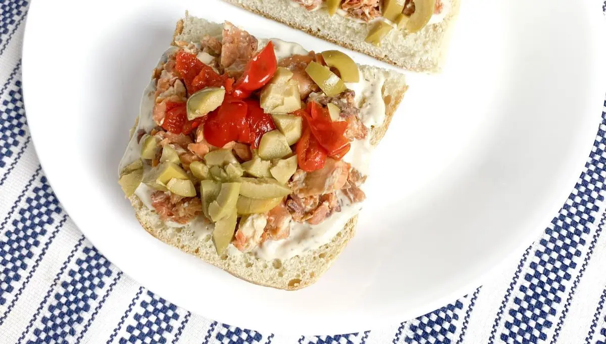 Niçoise salmon sandwich on a plate.