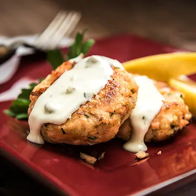 Thanksgiving fish recipes with two salmon cakes on a plate.