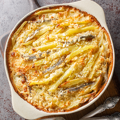 Janssons frestelse, a classic Christmas fish dish in Sweden, consists of anchovies, potatoes, and a creamy sauce.