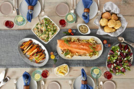 How to eat more fish with a table full of cooked fish, vegetables, and other food.