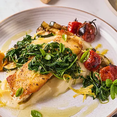 Reasons to love fish with a plate of cooked sea bass and greens