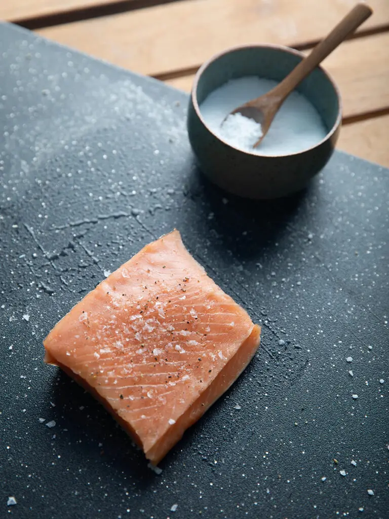 Cooking fish mistakes with a filet of salmon sprinkled with salt.