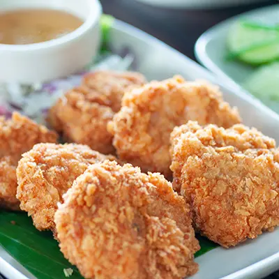 Shrimp cakes serve on green leaf in white plate on wooden table,