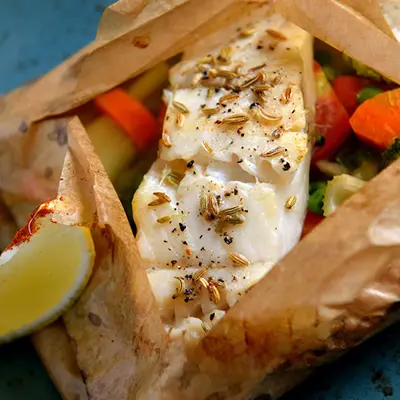 Copper River Seafoods fish cooked in parchment paper with vegetables.