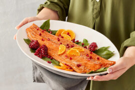 mediterranean menu woman holding platter cooked salmon