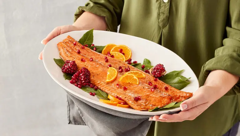 mediterranean menu woman holding platter cooked salmon